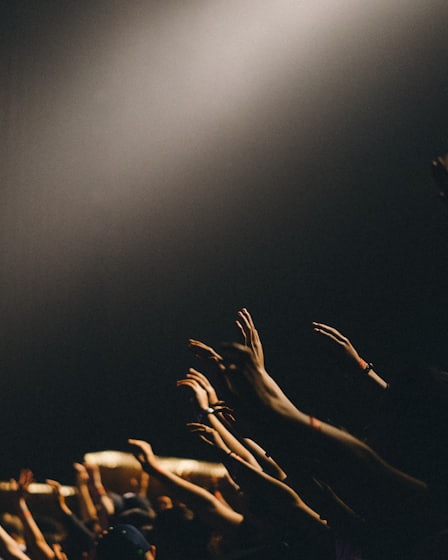 Hands raised in a warm-lit room